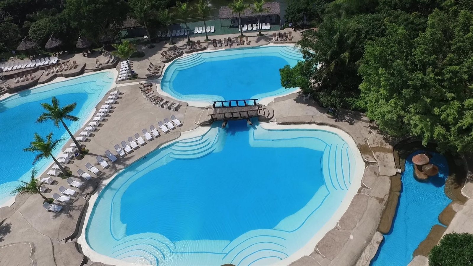 Vista aérea de las piscinas naturales de Güembé rodeadas de palmeras